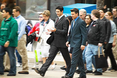 business men walking across road talking