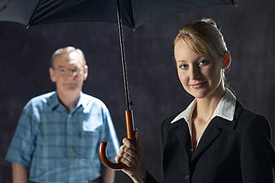 woman with umbrella and person standing in background