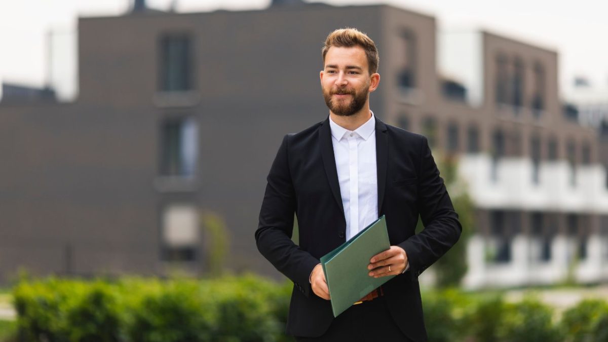 real estate agent standing outside of commercial buildings