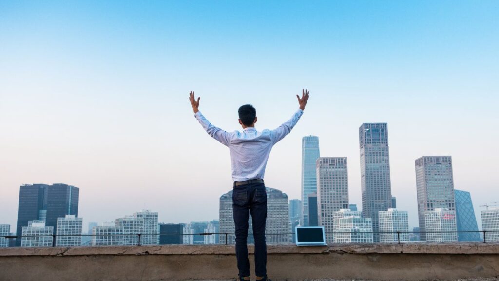 man standing on building top overlooking city